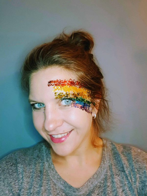 vrouw met pride glitter op gezicht